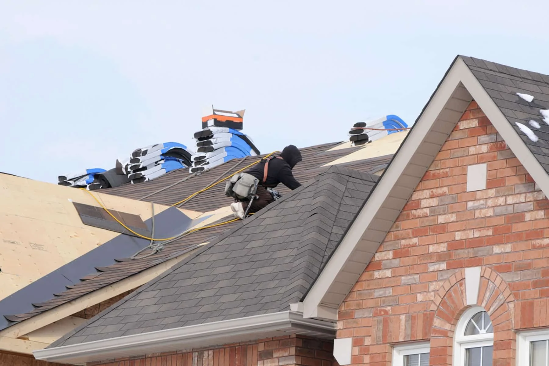Roofer installing architectural shingles on a residential home