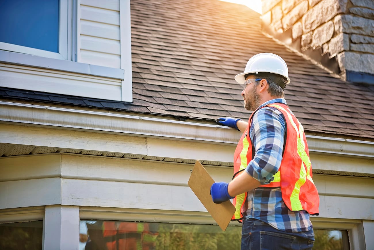 Roofing professional inspecting a residential roof