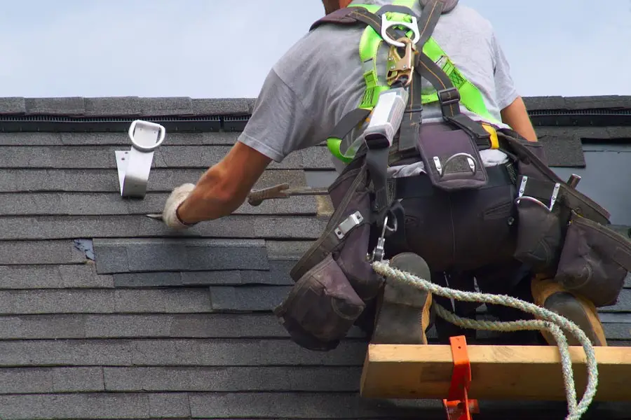 Roofer repairing damaged shingles